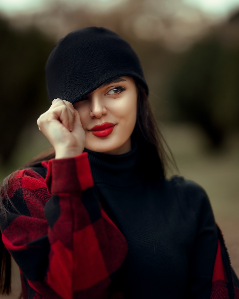 Photo by zana pq a woman wearing a black hat and a red and black shirt